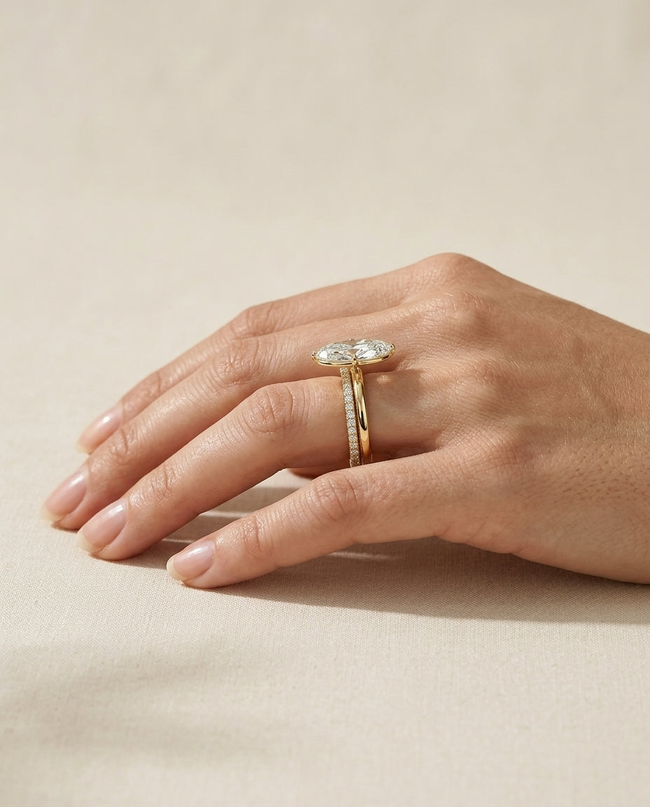 A MARLII Cutaway engagement ring worn on the hand beside a straight wedding band, seen from the side